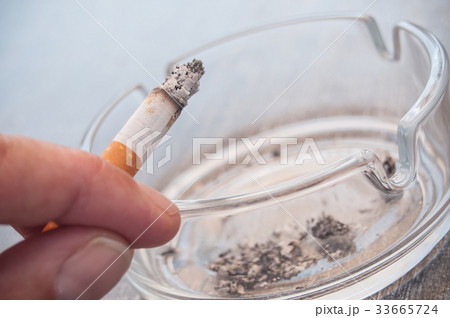 hand of man with cigarette and ashtray 33665724