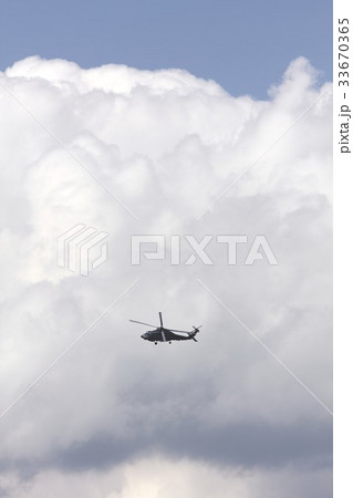 雄大積雲を背景に旋回飛行する米海軍の艦載機SH-60Bシーホーク対潜ヘリコプター 33670365