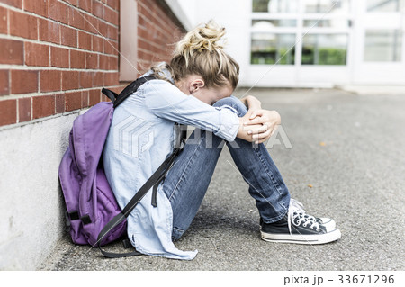 Unhappy Pre teen girl at school Unhappy Pre teen girl at school 33671296