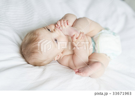 Cute happy 7 month baby girl in diaper lying and Cute happy 7 month baby girl in diaper lying and 33671963