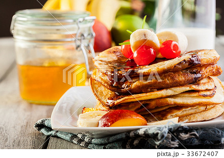 Pancakes with chocolate sauce fruit and milk Pancakes with chocolate sauce fruit and milk 33672407