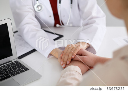 Hand of doctor reassuring her female patient Hand of doctor reassuring her female patient 33673225