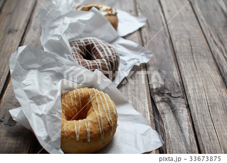 一列に並べた包み紙に入りのフワフワドーナツ3種類 33673875