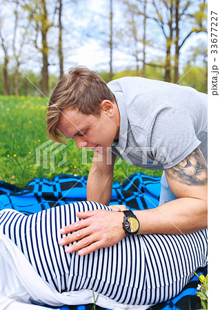 man touching the belly of a pregnant woman 33677227