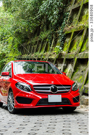 赤い車と苔の生えた防護壁の風景 33680908