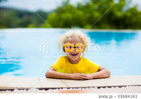 Child with goggles in swimming pool. Kids swim. Child with goggles in swimming pool. Kids swim. 33684161