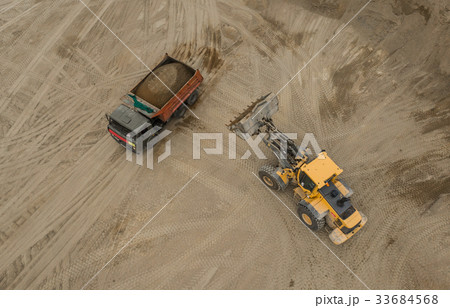 Aerial view of bulldozer pouring sand into truck 33684568