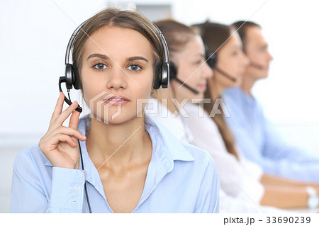 Call center operator in headset while consulting Call center operator in headset while consulting 33690239