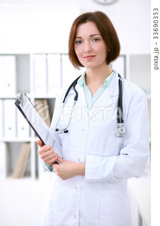 Young brunette female doctor standing with Young brunette female doctor standing with 33690353