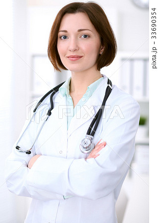 Young brunette female doctor standing with arms Young brunette female doctor standing with arms 33690354