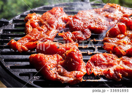 Grilling pork steaks on barbecue grill Grilling pork steaks on barbecue grill 33691693