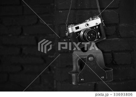 Old film camera on black wall. Image for design 33693806