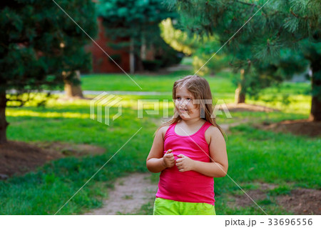 Beautiful little girl on the street through 33696556