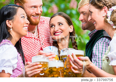 Friends having fun in beer garden while clinking 33700756