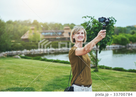 Woman capturing herself with personal camera 33700784