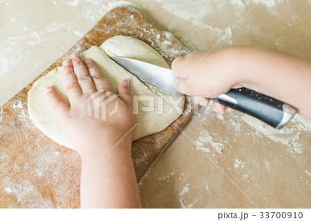 A child cuts the raw dough A child cuts the raw dough 33700910