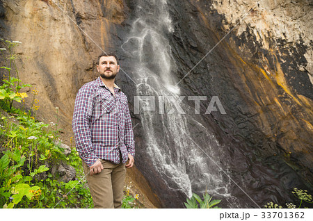 A bearded hipster in a plaid shirt stands against A bearded hipster in a plaid shirt stands against 33701362