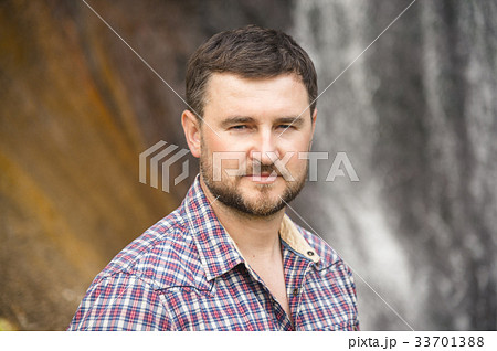 Close-up portrait of a bearded hipster against a Close-up portrait of a bearded hipster against a 33701388