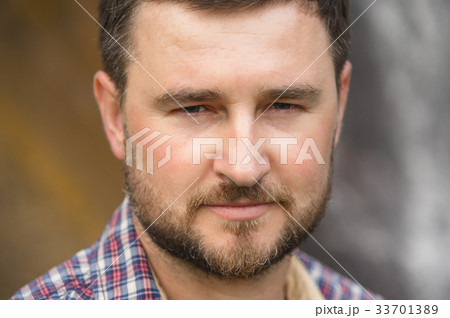 Close-up portrait of a bearded hipster against a Close-up portrait of a bearded hipster against a 33701389