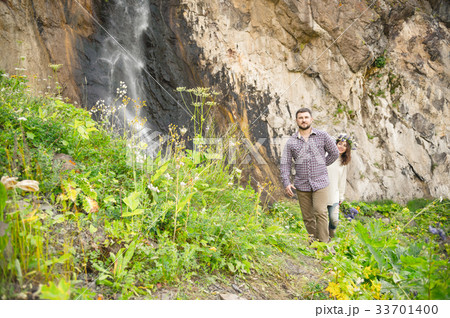 Hipster with a beard leads his bride in nature 33701400