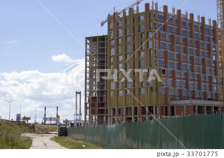 Crane and building under construction against blue 33701775