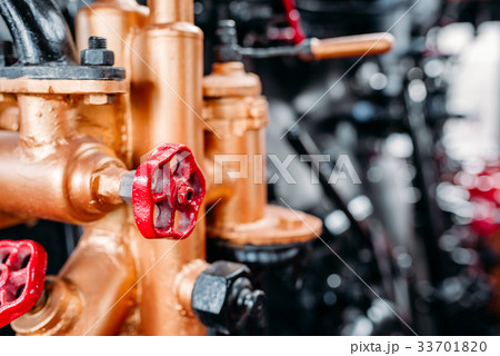 Old steam train cabine, valves, pipes closeup Old steam train cabine, valves, pipes closeup 33701820
