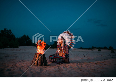 Young American Indian woman against fire Young American Indian woman against fire 33701882
