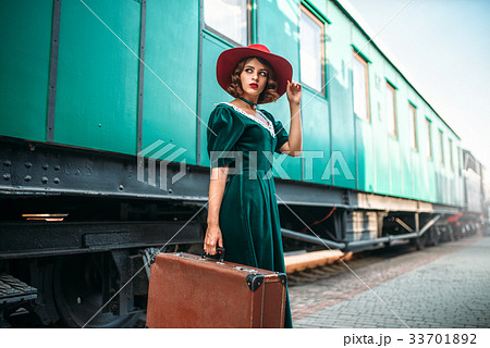 Young old-fashioned woman travels on retro train 33701892