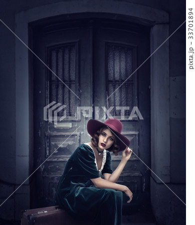Woman sits on suitcase, vintage style fashion Woman sits on suitcase, vintage style fashion 33701894