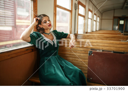 Female traveler in retro train, old wagon interior Female traveler in retro train, old wagon interior 33701900