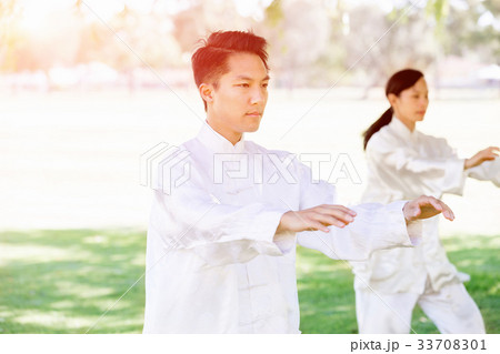 People practicing thai chi in park People practicing thai chi in park 33708301