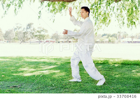 Handsome man practicing thai chi Handsome man practicing thai chi 33708416