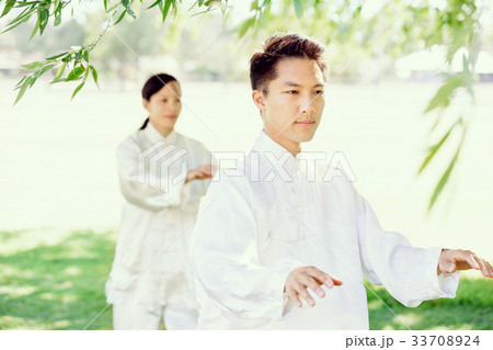 People practicing thai chi in park People practicing thai chi in park 33708924