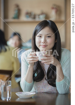 ティーカップを持ち微笑む女性 ティーカップを持ち微笑む女性 33709127