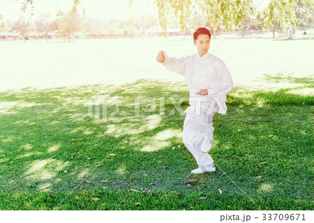 Handsome man practicing thai chi Handsome man practicing thai chi 33709671