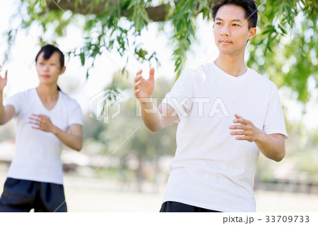 People practicing thai chi in park 33709733