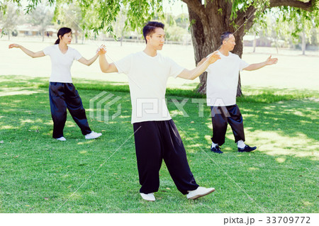 People practicing thai chi in park People practicing thai chi in park 33709772