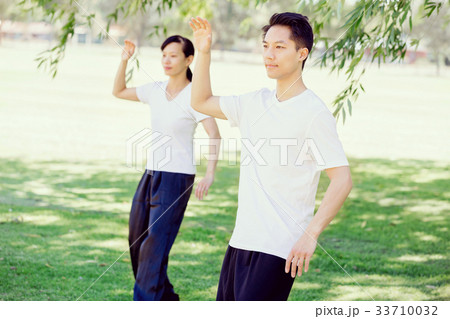 People practicing thai chi in park 33710032