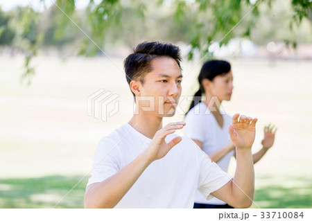 People practicing thai chi in park People practicing thai chi in park 33710084