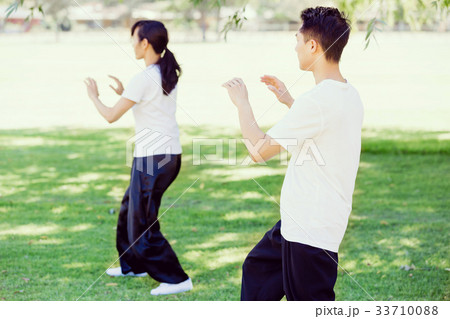 People practicing thai chi in park People practicing thai chi in park 33710088