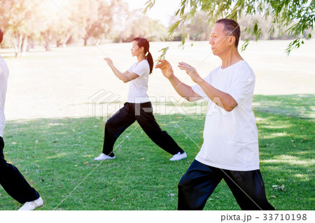 People practicing thai chi in park 33710198