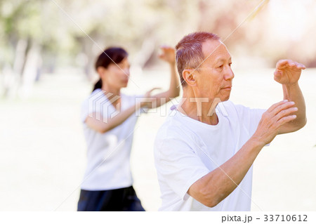 People practicing thai chi in park People practicing thai chi in park 33710612