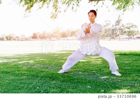 Handsome man practicing thai chi Handsome man practicing thai chi 33710696