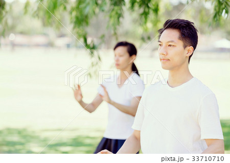 People practicing thai chi in park 33710710