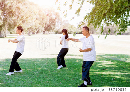 People practicing thai chi in park People practicing thai chi in park 33710855