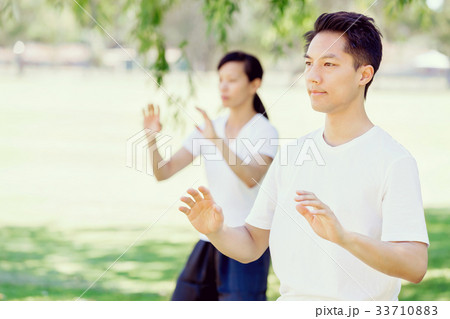 People practicing thai chi in park People practicing thai chi in park 33710883