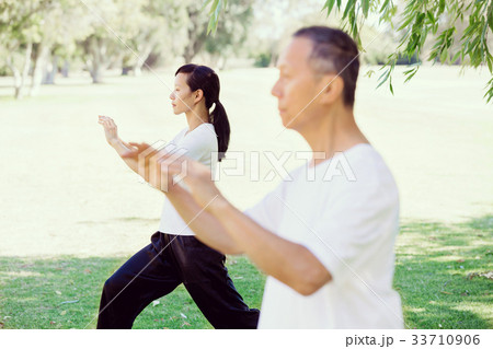 People practicing thai chi in park 33710906