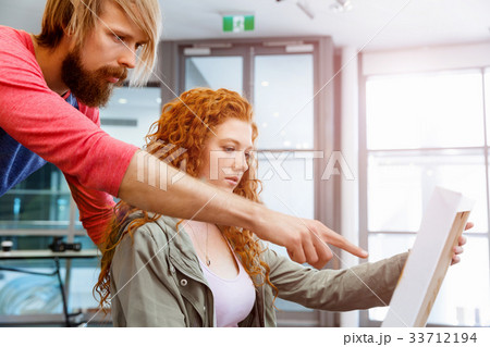 Young caucasian couple standing in a gallery and contemplating artwork Young caucasian couple standing in a gallery and contemplating artwork 33712194
