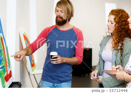 Young people standing in a gallery and contemplating artwork Young people standing in a gallery and contemplating artwork 33712446