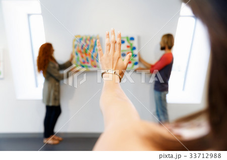 Young artists in gallery hanging painting on walls Young artists in gallery hanging painting on walls 33712988